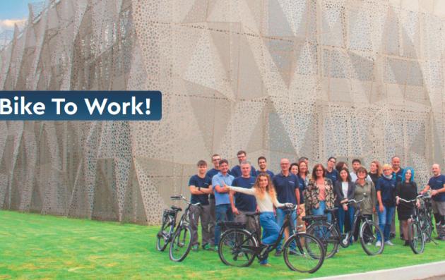 The people in the image are posing with bicycles, suggesting the theme of biking to work.